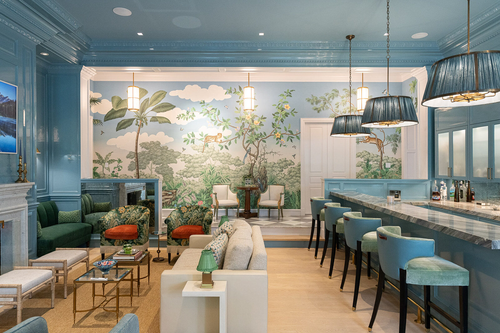 Blue paneled lounge and bar with a tropical jungle mural