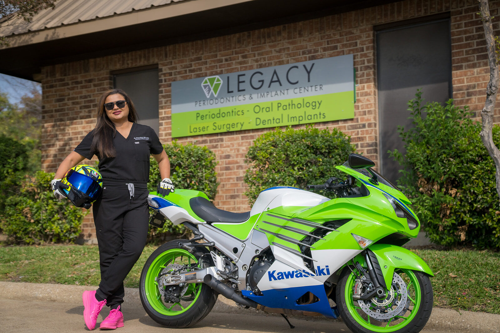 Periodontist beside her motorcycle outside the practice