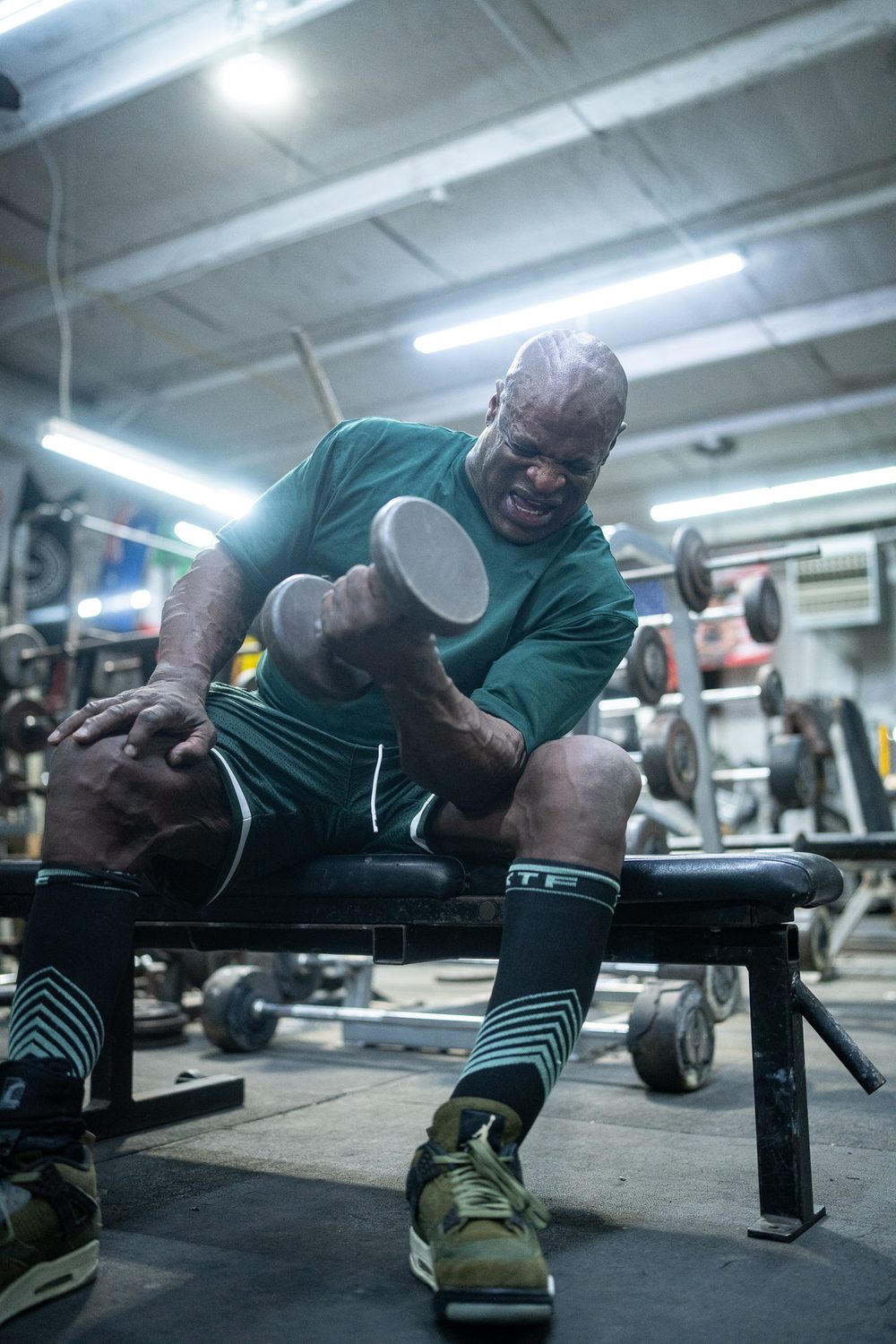 Ronnie Coleman powering through a seated dumbbell curl