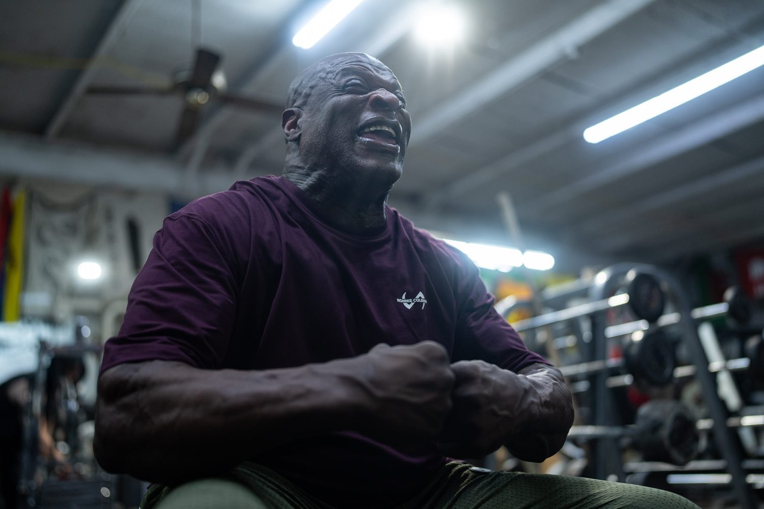 Ronnie Coleman laughing mid-set in a maroon training tee