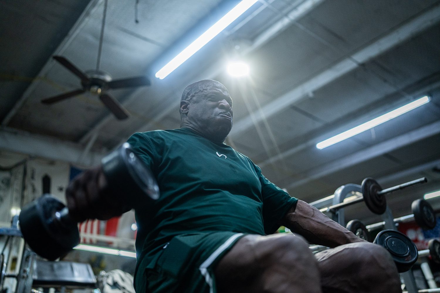 Low-angle view of Ronnie Coleman pressing dumbbells