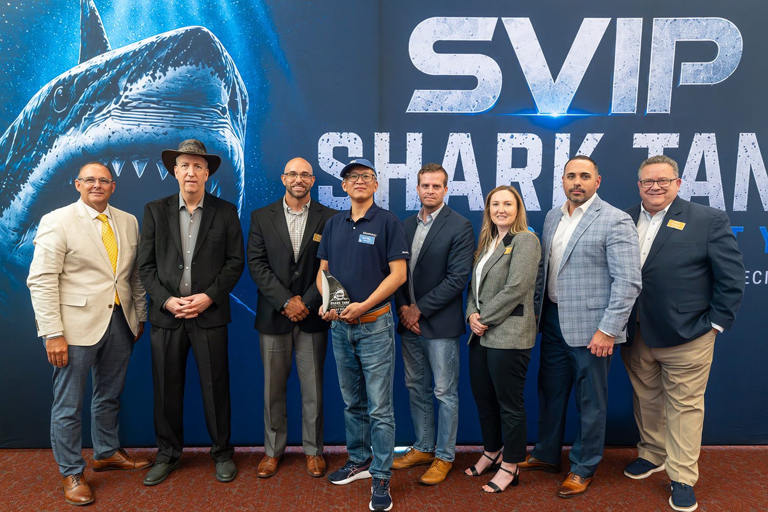 Group photo of finalists and judges with the winning trophy