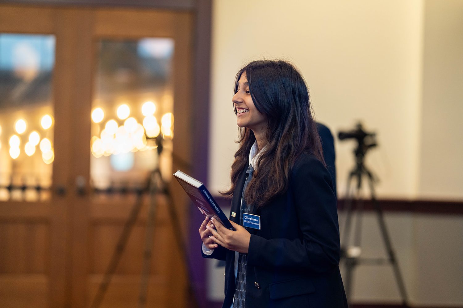 Presenter smiling while delivering a pitch with notes in hand